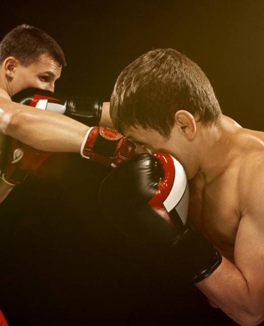 Two professional boxers in action under dramatic lighting, symbolising legal support for athletes and entertainers provided by SWVG Inc.