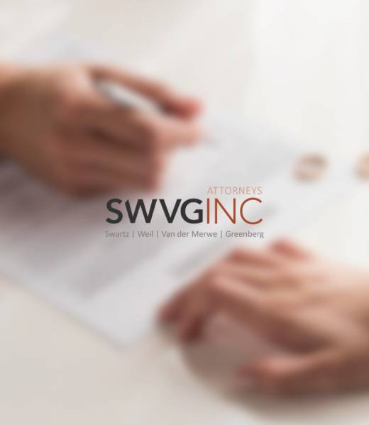 Close-up of hands over divorce paperwork with wedding rings on the table, illustrating family law services including divorce, parenting arrangements and protection orders.