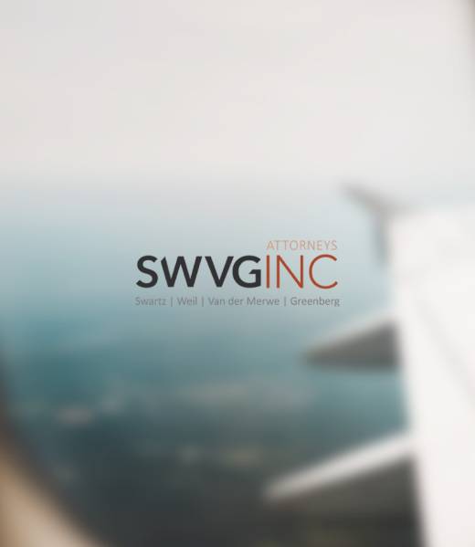 Airplane wing seen from a window over distant landscape - representing cross-border legal support for contracts, disputes and compliance.