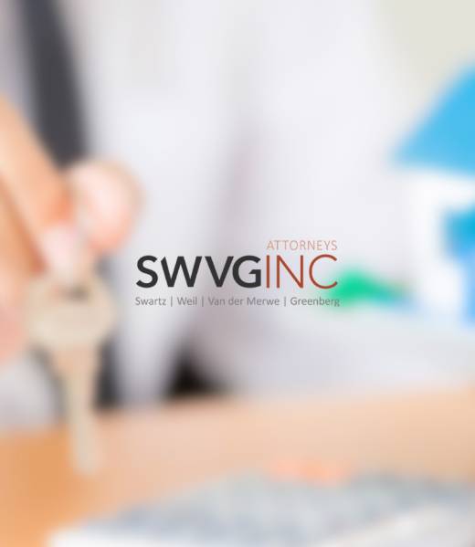 Hand holding a house key beside a small model house, representing property law and evictions.